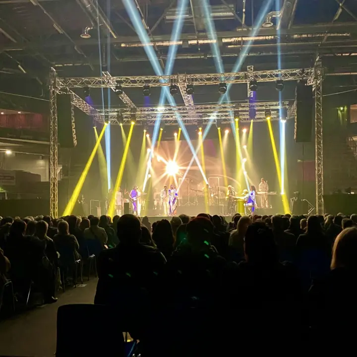 Konsertin valoshow, keltaiset ja valkoiset valonsäteet lavalla